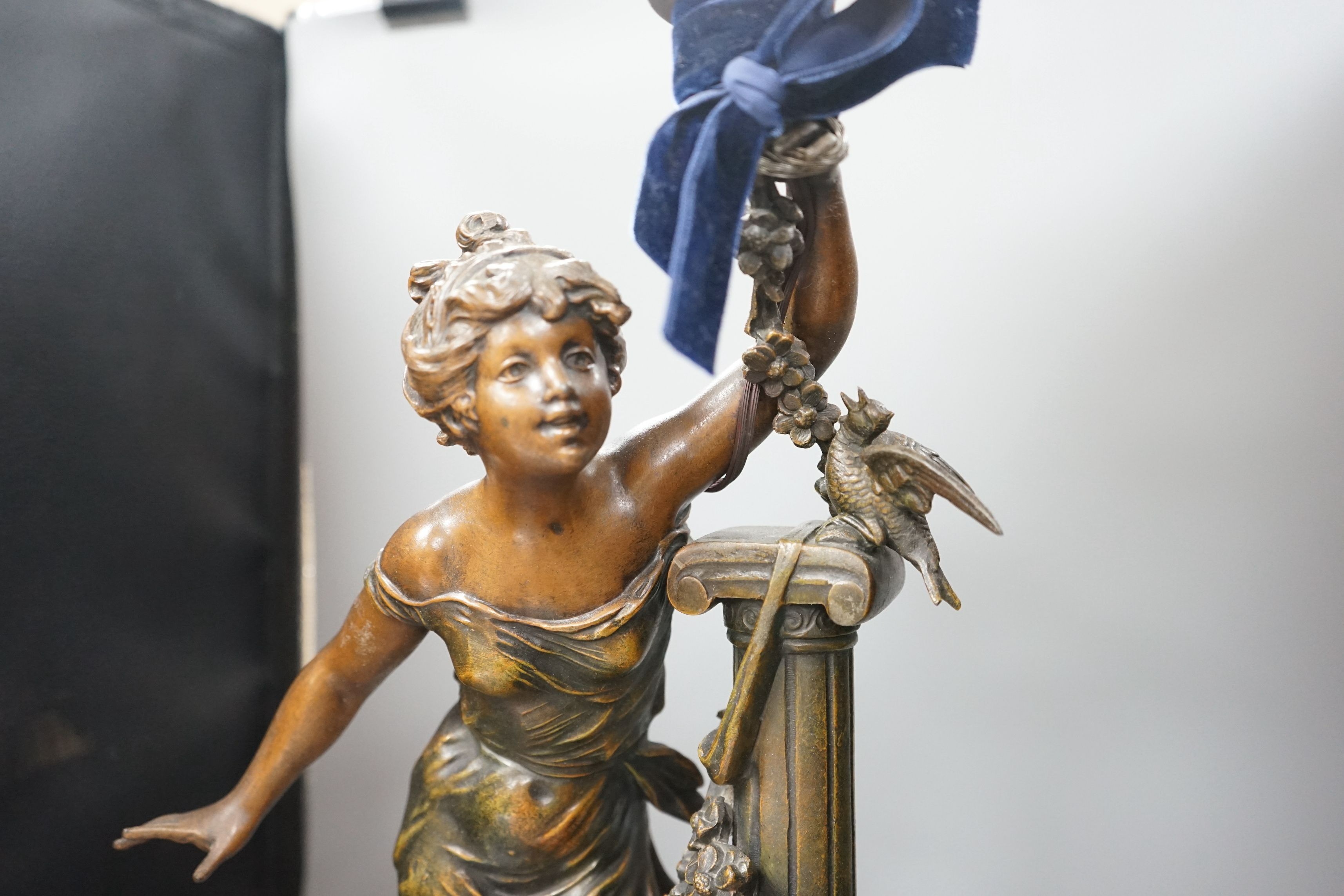 An Art Nouveau style figural lamp, with an amber glass flambe shaped shade, 77cms high including shade